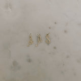 image of gold letter pendants a, m and s against a marble backdrop