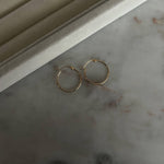 image of two gold hoops on a marble table