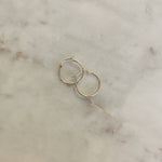 image of two gold hoops on top of a marble table