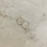 image of two gold hoops on top of a marble table