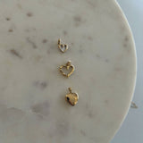 image of three 14k gold heart pendants on a white marble block