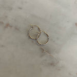 image of two tone earrings on top of a marble table