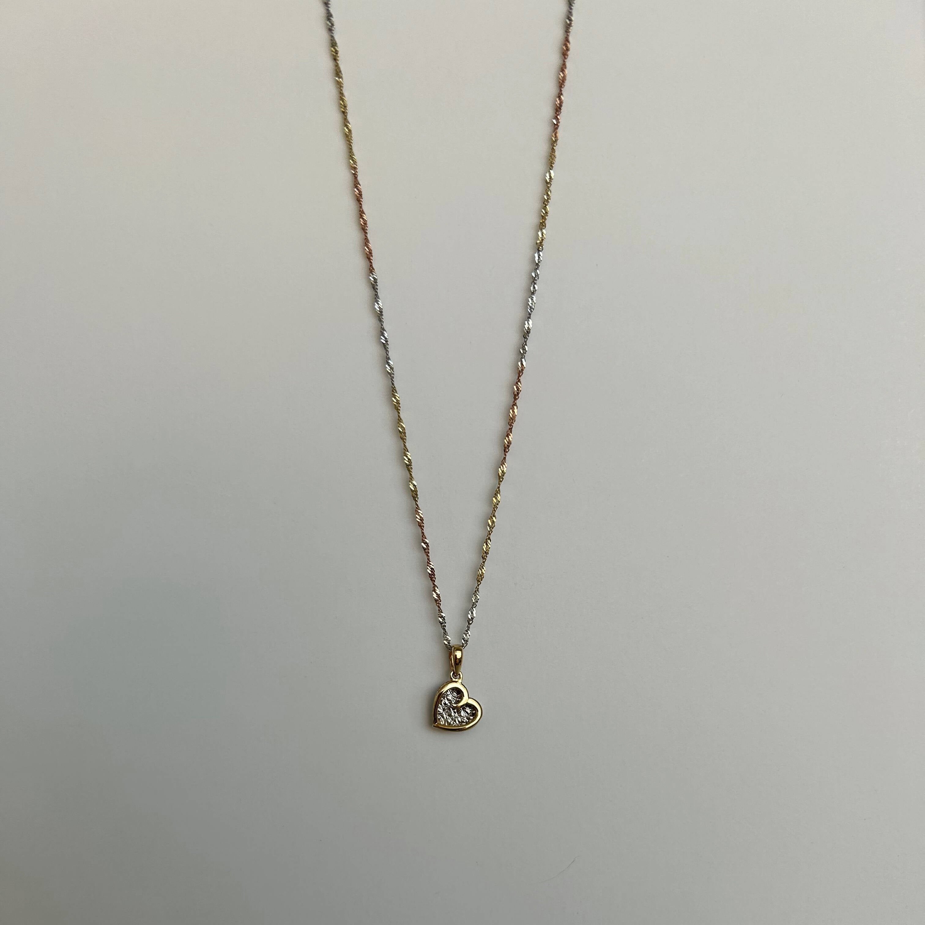 image of a heart pendant with a three tone rope singapore chain against a white backdrop